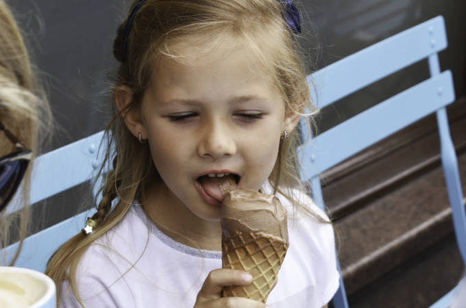 Kleines Mädchen geniesst Eis aus Waffel